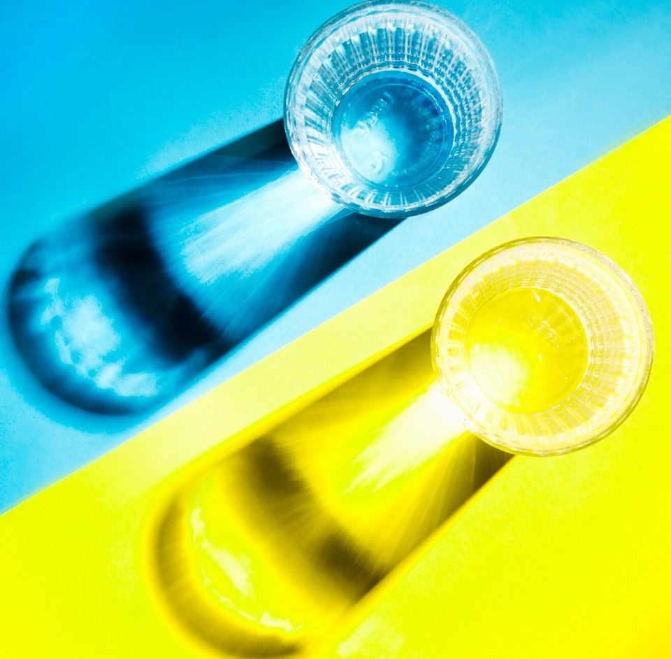 Glass cups on yellow and blue background